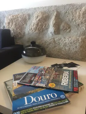 a table with two magazines on top of a table at An apartment with a view - Nó's place in Vila Nova de Gaia