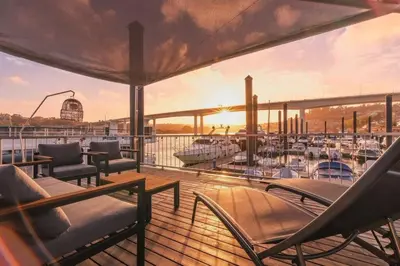 a deck on a yacht with chairs and a boat at SLEEPBOAT- Modern Houseboat in Porto in Bicas