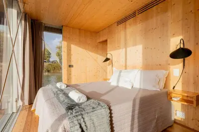 a bedroom with a bed in a room with a window at SLEEPBOAT- Modern Houseboat in Porto in Bicas