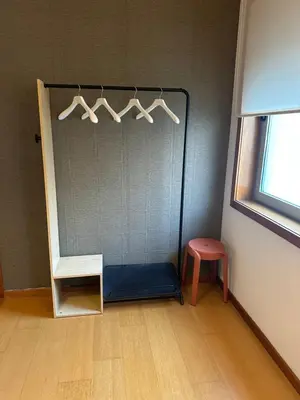 a room with a shelf with hangers and a stool at Burnay Porto Suites in Porto