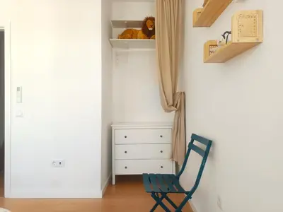 a blue chair in a room with a dresser at Charming Campanhã Family Home in Porto
