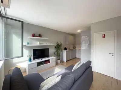 a living room with a couch and a television at Allegro Patio House in Porto