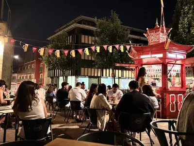 a group of people sitting at tables at an outdoor restaurant at Historic Porto Flat I Balcony & Views by MyMoradia in Porto