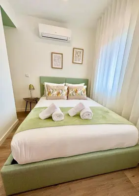 a bedroom with a large bed with towels on it at Historic Porto Flat I Balcony & Views by MyMoradia in Porto