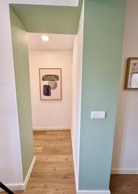 a hallway with green walls and wood floors at Historic Porto Flat I Balcony & Views by MyMoradia in Porto