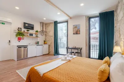 a bedroom with a large bed and a kitchen at DesKanzo Guest House - Raúl Doria in Porto