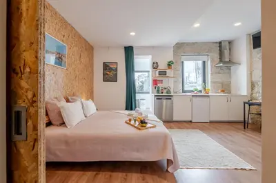 a small bedroom with a bed and a kitchen at DesKanzo Guest House - Raúl Doria in Porto