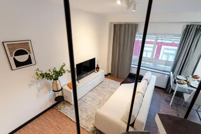 a living room with a couch and a tv at Duplex Studio in Art District by HostWise in Porto