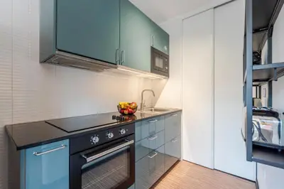 a kitchen with blue cabinets and a sink at Duplex Studio in Art District by HostWise in Porto