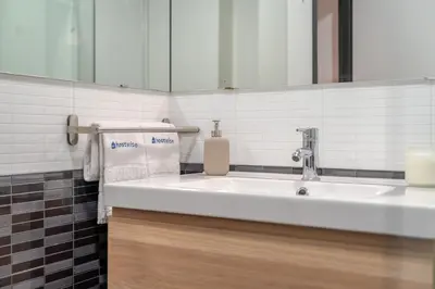 a bathroom with a white sink and a mirror at Duplex Studio in Art District by HostWise in Porto