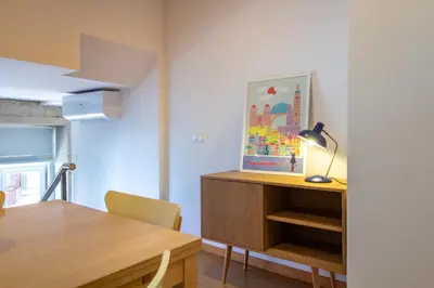 a dining room with a table and a desk with a lamp at Bright 1BR with Parking in Bolhão by LovelyStay in Porto
