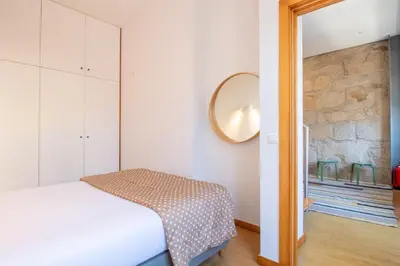 a bedroom with a bed and a mirror on the wall at Bright 1BR with Parking in Bolhão by LovelyStay in Porto
