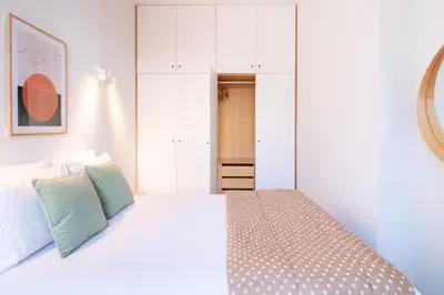 a bedroom with a bed with white cabinets at Bright 1BR with Parking in Bolhão by LovelyStay in Porto
