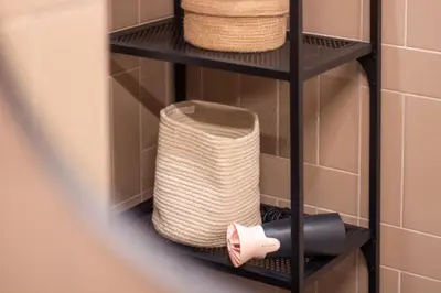 a shelf in a bathroom with a basket and towels at Bright 1BR with Parking in Bolhão by LovelyStay in Porto