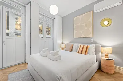 a white bedroom with a large bed with towels on it at GuestReady - Music Scale Studios in Porto