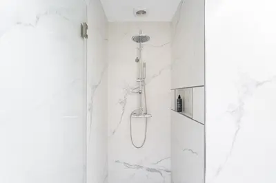 a bathroom with a shower with white marble walls at GuestReady - Music Scale Studios in Porto