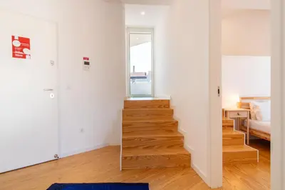 a staircase in a room with white walls and wooden floors at Morro Flat w Terrace by LovelyStay in Vila Nova de Gaia
