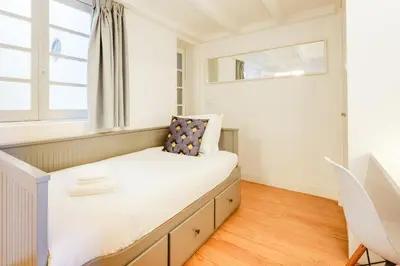 a small bedroom with a bed and a window at Duque Luxury in Porto