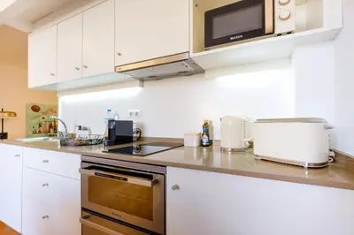 a kitchen with white cabinets and a microwave at Duque Luxury in Porto