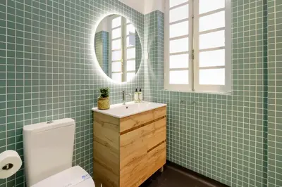 a green tiled bathroom with a sink and a mirror at Duque Luxury in Porto
