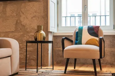 a living room with a chair and a vase on a table at Luxury Style 20 with AC Downtown Porto near Metro in Porto