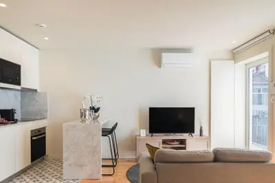 a living room with a couch and a tv at Luxury Style 30 with AC Downtown Porto near Metro in Porto