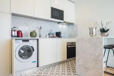 a kitchen with a washer and dryer in a room at Luxury Style 30 with AC Downtown Porto near Metro in Porto