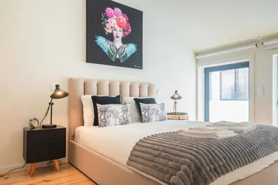 a bedroom with a large bed with a painting on the wall at Luxury Style 30 with AC Downtown Porto near Metro in Porto