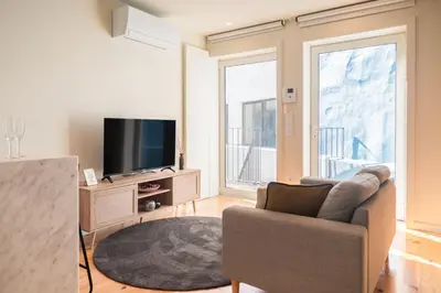 a living room with a couch and a television at Luxury Style 30 with AC Downtown Porto near Metro in Porto