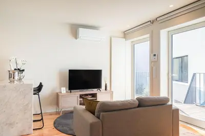 a living room with a couch and a flat screen tv at Luxury Style 30 with AC Downtown Porto near Metro in Porto