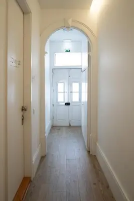 an empty hallway with a white door and a wooden floor at Cozy Studio with Workspace by HostWise in Porto