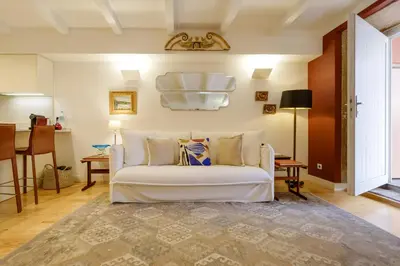 a living room with a white couch and a table at Quinta dos Cedros Garden & Terrace in Porto