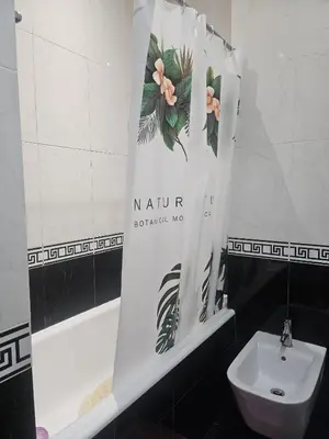 a bathroom with a shower curtain next to a toilet at Apartamento Quarto Compartilhado Porto in Porto