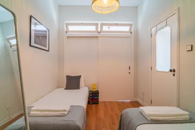 a small bedroom with two beds and a mirror at São João by Casa de Gondomil in Porto