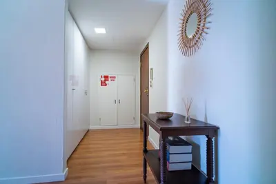a hallway with a table and a mirror on the wall at São João by Casa de Gondomil in Porto