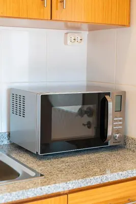 a microwave oven sitting on a counter in a kitchen at São João by Casa de Gondomil in Porto