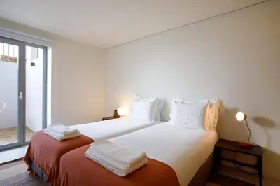 a bedroom with a white bed and a lamp at Casa Aurelia in Porto