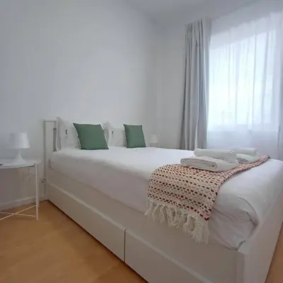 a white bed in a white room with a window at Your Home in Porto 1480 Style and Comfort in Porto