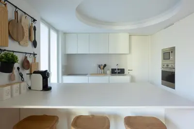 a kitchen with white cabinets and a white counter top at My Home is Yours in Porto