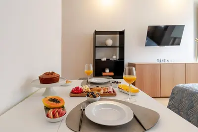 a table with food and two glasses of wine at Central & Cozy Studio by HostWise in Vila Nova de Gaia