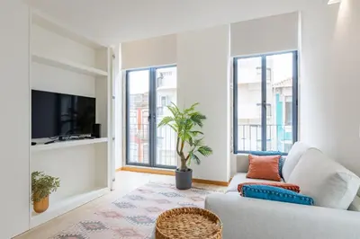 a living room with a couch and some windows at Urban Style in Bonfim | Porto in Porto