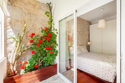 a bedroom with red flowers on the wall at Stunning Designer Flat with Balcony Heart of Porto in Porto