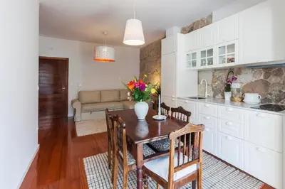 a kitchen and dining room with a table and chairs at Stunning Designer Flat with Balcony Heart of Porto in Porto
