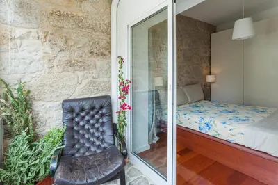 a bedroom with a bed and a glass door at Stunning Designer Flat with Balcony Heart of Porto in Porto