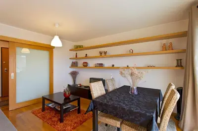 a dining room with a black table and chairs at Modern and quiet T1 with private Garage in Porto