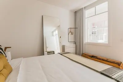a bedroom with a large bed and two windows at Porto River in Porto