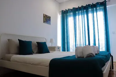 a bedroom with a large bed with blue curtains at Sweet apartment in Porto in Porto