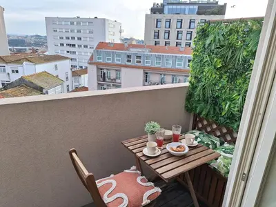 a balcony with a table with food and drinks on it at Oporto Hideaway 3 - Poveiros Square Balcony in Porto