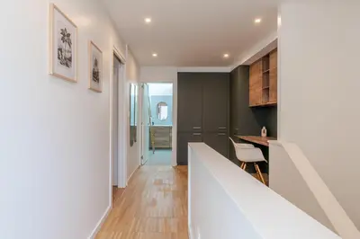 a kitchen with a white counter and a dining room at Stylish Open-Plan Flat with Swimming Pool by HostWise in Porto