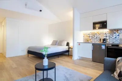 a living room with a bed and a table in a room at Caldeireiros 95 by LovelyStay in Porto